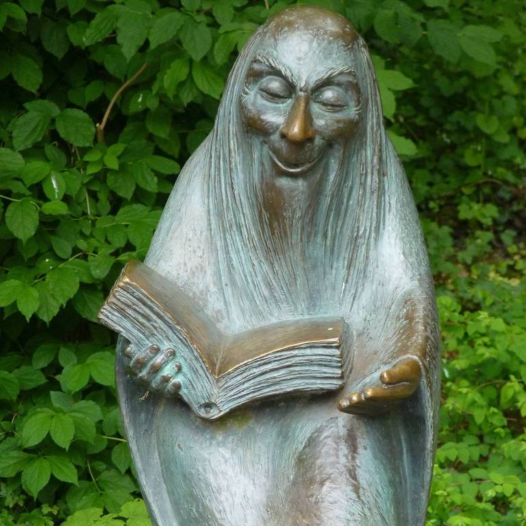 Estátua de um contador de histórias com um livro na mão