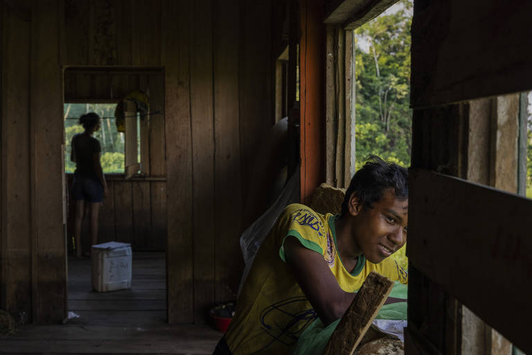 Filho do cacique Franciney Silva de Lima, 35, observam da janela de casa o movimento na terra indígena Boca do Mucura, próximo a Fonte Boa