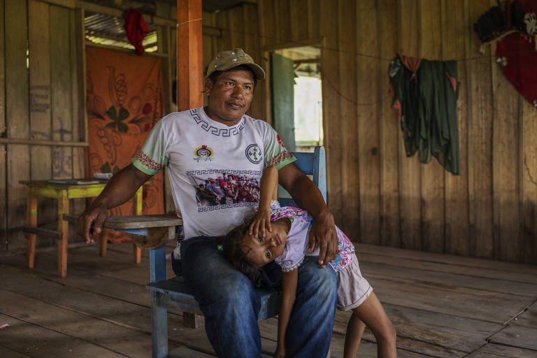 O tuxaua (cacique) Franciney Silva de Lima, 35, com uma de suas filhas em sua casa na terra indígena Boca do Mucura, próximo a Fonte Boa