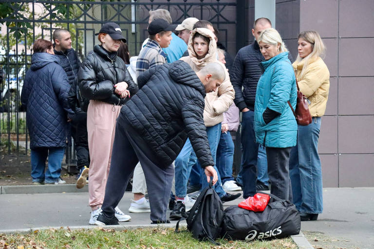 Jovem se despede da família em centro de alistamento russo em Moscou