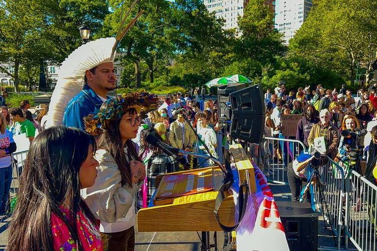 Indígenas discursam em um palco ao ar livre