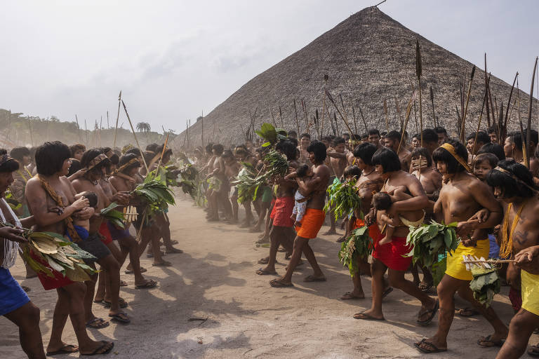 Dezenas de indígenas enfileirados com lanças nas mãos