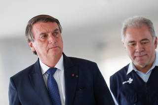 Brazil's President Jair Bolsonaro walks with Health Minister Marcelo Queiroga in Brasilia