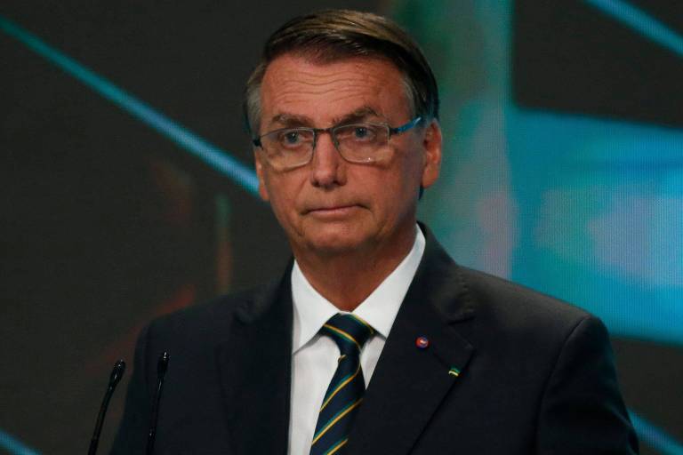 Imagem mostra o presidente Jair Bolsonaro durante debate entre candidatos a presidente, promovido pelo SBT e outros veículos de mídia. Ele é um homem branco e veste um terno escuro, com uma camisa branca. Está de óculos.
