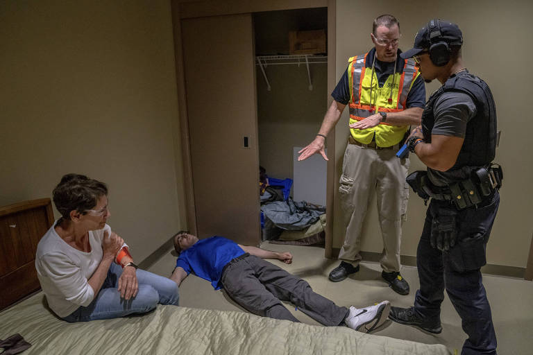 A trainer, police officer and actors in a knife attack scenario at the State Preparedness Training Center in Oriskany, N.Y., June 29, 2022. The 1,100-acre, $50 million facility in upstate New York simulates a terrifying set of scenarios, from terrorist attacks to flash flooding. (Juan Arredondo/The New York Times)