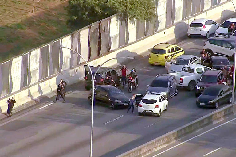 Motoristas e passageiros abandonam veículos e se abrigam de tiroteio na Linha Vermelha, Rio de Janeiro.