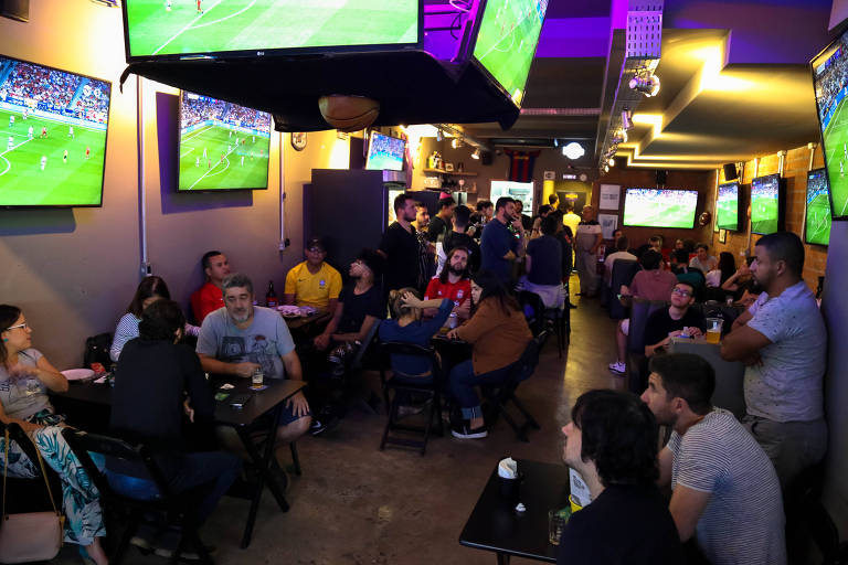Pessoas assistindo a um jogo no Resenha Sports Bar