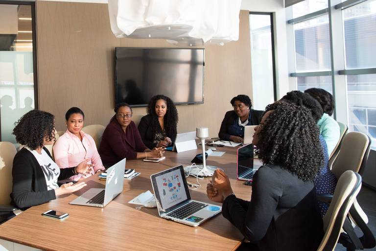 Foto mostra mulheres negras em uma sala de reunião