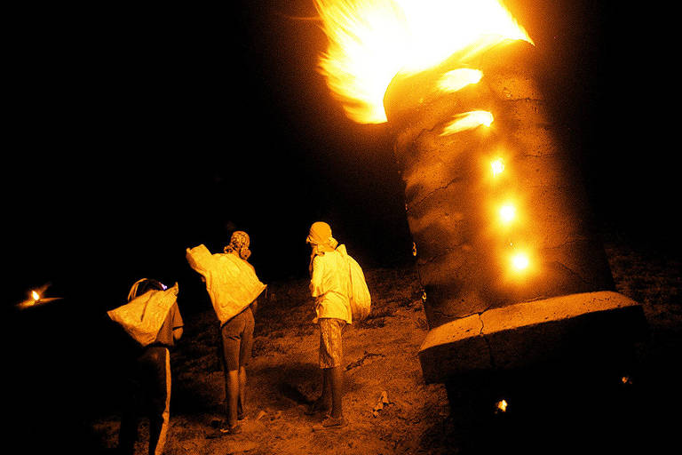 Meninos da favela Cidade das Crianças pegam alimentos com prazos de validade vencidos descarregados por supermercados no aterro sanitário Bandeirantes, perto do fogo causado pela queima de gás metano