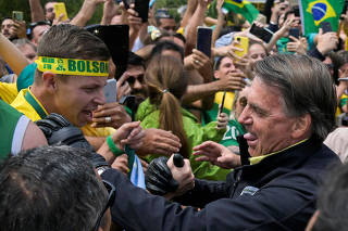 Brazil's President and candidate for re-election Jair Bolsonaro greets supporters in Pocos de Caldas