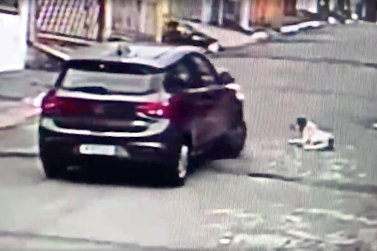 Carro ao lado de cachorro vira-lata em uma rua de Guaianases, na zona leste de São Paulo; motorista atropelou o animal na sequência e a acabou preso 