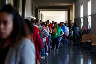 Brazil citizens wait in line to cast their vote in the country's elections, in Lisbon