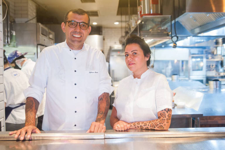 A foto mostra os chefs Jefferson Rueda e Janaína Torres Rueda na bancada do restaurante