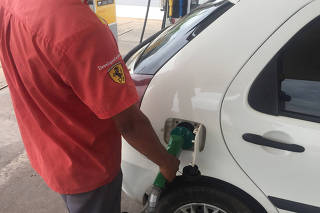 FILE PHOTO: A gas station worker fills up a car's tank with ethanol in Cuiaba
