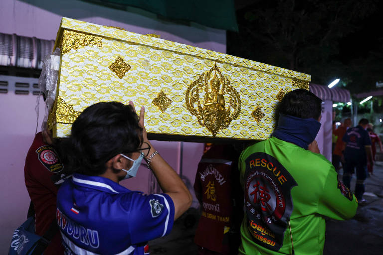 Equipes de resgate carregam caixão de vítima no hospital Udon Thani, na província de Udon Thani