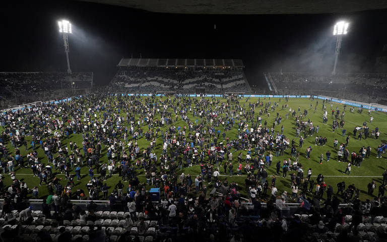 Multidão de torcedores espalhados pelo gramado do estádio