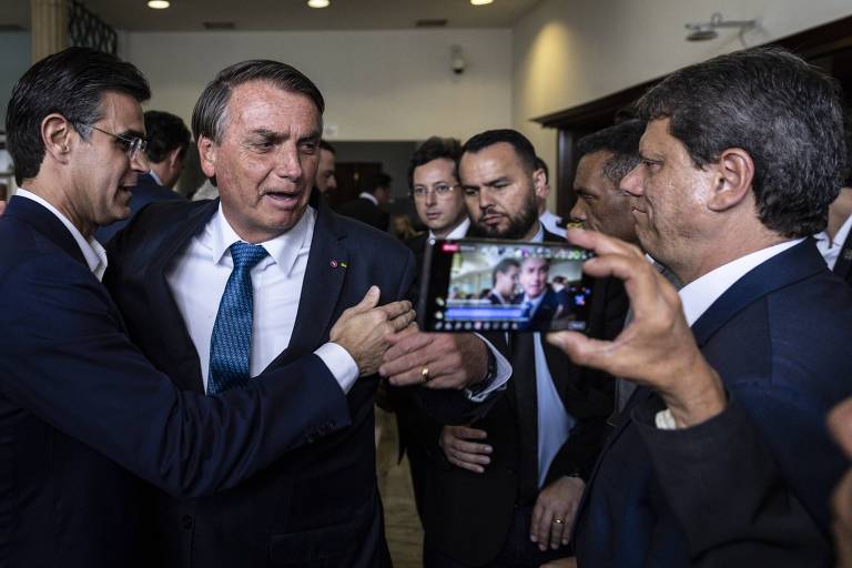O governador de São Paulo, Rodrigo Garcia, cumprimenta o presidente Jair Bolsonaro, observado pelo candidato Tarcísio de Freitas