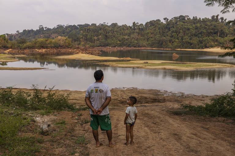 O ribeirinho Andrelino do Nascimento observa com seu neto o rio Xingu, no lote onde foi reassentado na região da Volta Grande