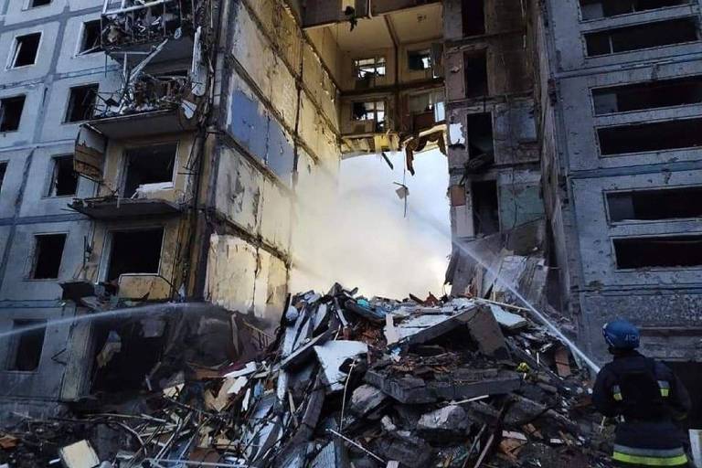 Bombeiro trabalha em área residencial atingida durante bombardeio em Zaporíjia, na Ucrânia