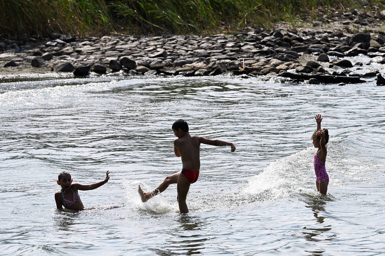 Crianças brincam no lago Como, na Itália, em julho
