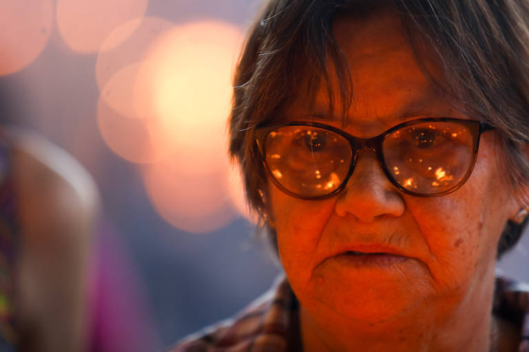 Fiel acende vela e faz orações na Capela das Velas. 