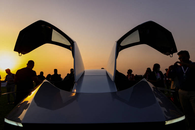 Convidados e repórteres conferem o carro voador eVTOL X2, da XPeng