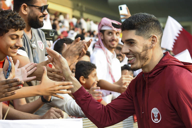 O jogador Karim Boudiaf cumprimenta torcedores após treino aberto da seleção do Qatar