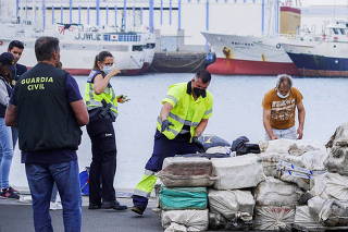 Police officers discharge drugs from the fishing boat 