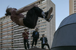 Members of the On The Spot Parkour collective athletes training on a Paris rooftop on Sept. 25, 2022. The sport was invented in the 1990s by David Belle, a Frenchman, as a way to travel across urban landscape as gracefully and dynamically as possible.  (Mauricio Lima/The New York Times)
