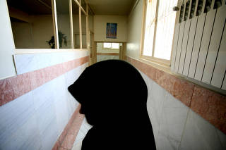 FILE PHOTO: A female prison guard stands along a corridor in Tehran's Evin prison June 13, 2006. Iranian police ..