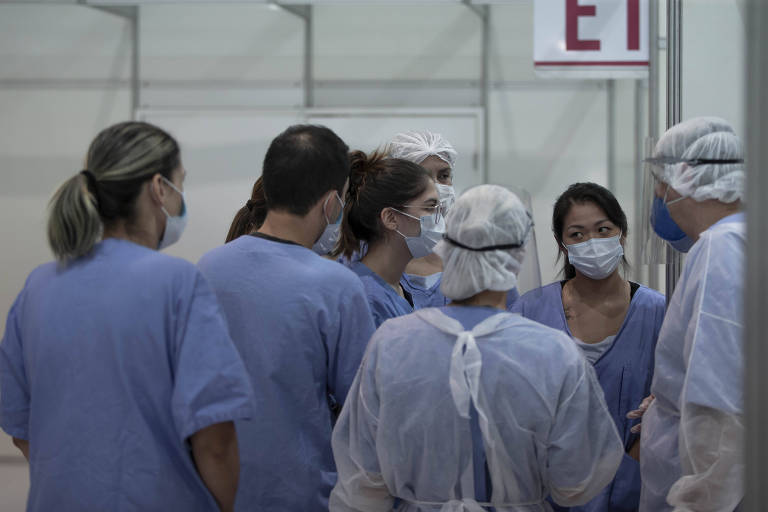 Enfermeiros conversam em um hospital de campanha
