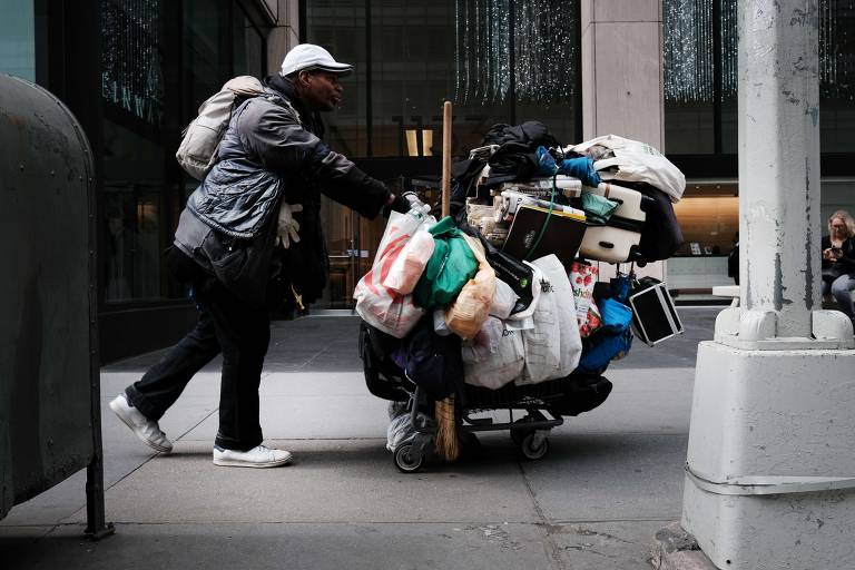 Homem em situação de rua caminha em Manhattan, em Nova York 

