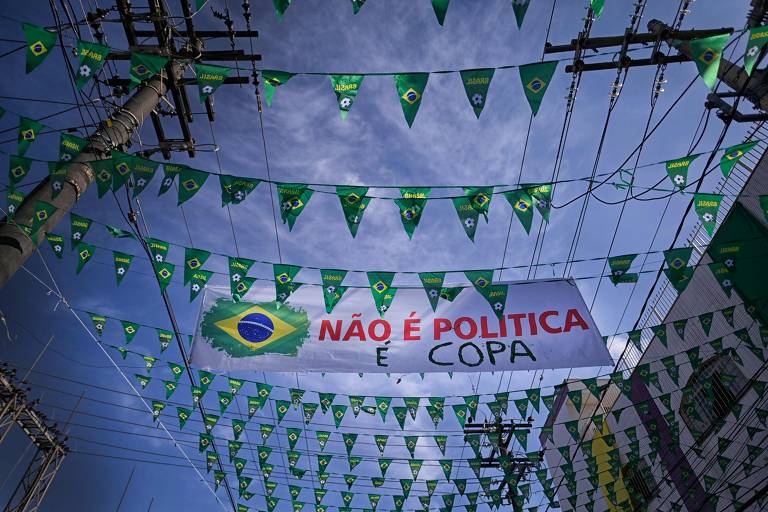 Bandeiras do Brasil enfeitam rua em Belo Horizonte, entre elas pode-se ver uma faixa que diz: "Não é política, é Copa"