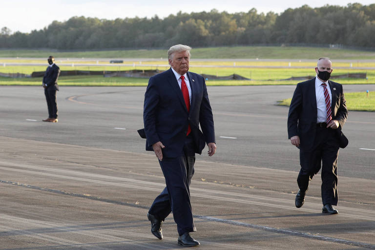 Então presidente dos EUA, Donald Trump, e o agente do Serviço Secreto Bobby Engel caminham até o Força Aérea Um antes de um comício de campanha em The Villages, na Flórida