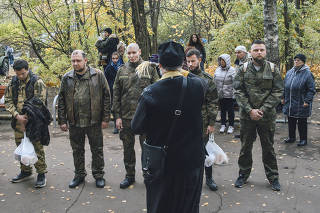 A Russian Orthodox priest performs a blessing for conscripted men in Moscow on Tuesday, Oct. 11, 2022. (Nanna Heitmann/The New York Times)