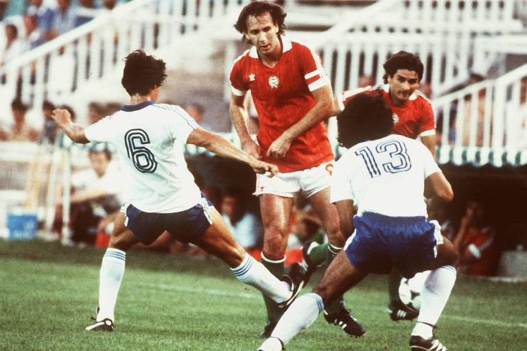 O húngaro Nyilasi (de vermelho) tenta passar por Ventura (número 6) e Rivas, de El Salvador, na partida entre as duas seleções na Copa de 1982