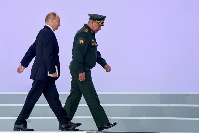 O presidente russo Vladimir Putin (à esq.) e o ministro da Defesa Sergei Choigu durante cerimônia de abertura de fórum técnico militar internacional, em Moscou