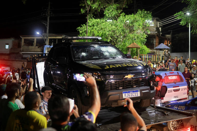 Pessoas tiram fotos de viatura da Polícia Federal baleada, após  Roberto Jefferson ter disparado contra a polícia enquanto resistia à prisão ordenada pelo Supremo Tribunal Federal, em sua casa em Comendador Levy Gasparian, interior do estado do Rio de Janeiro