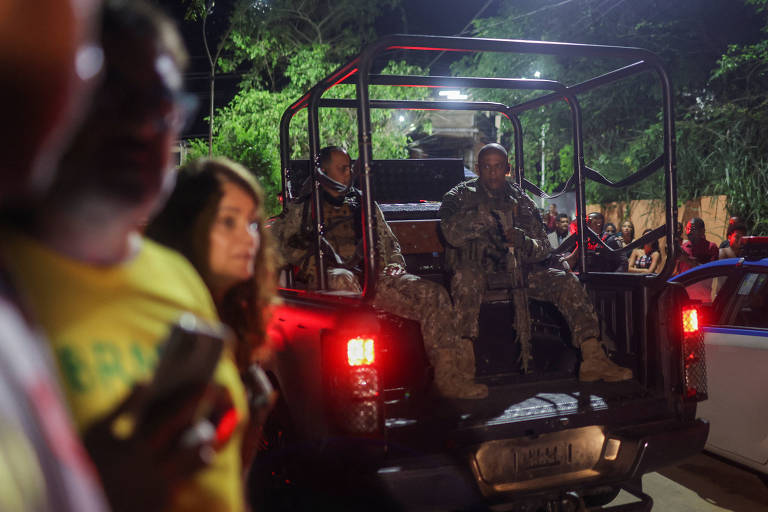 Membros das forças de segurança fazem retaguarda em veículo oficial enquanto apoiadores de Roberto Jefferson, que atirou contra a polícia ao resistir à prisão ordenada pelo Supremo Tribunal Federal, fazem manifestação perto de sua casa em Comendador Levy Gasparian, interior do estado do Rio de Janeiro