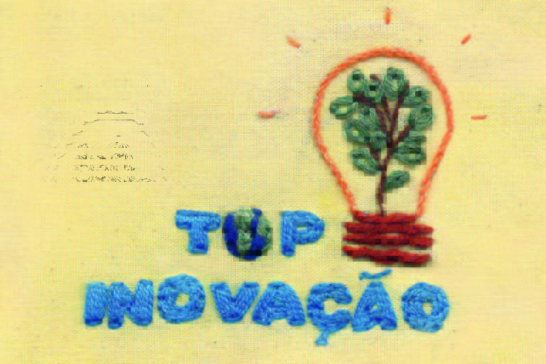 Bordado escrito Top Inovação, letras azuis, desenho de uma lâmpada com folhas dentro. Ilustração para a revista Top of Mind 2022