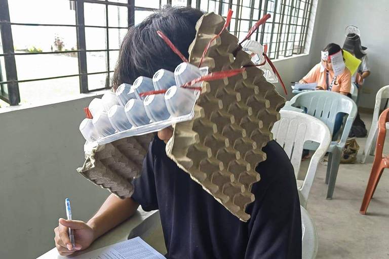 Estudantes nas Filipinas improvisam chapéus 'anticola' com caixas de ovos e papelão