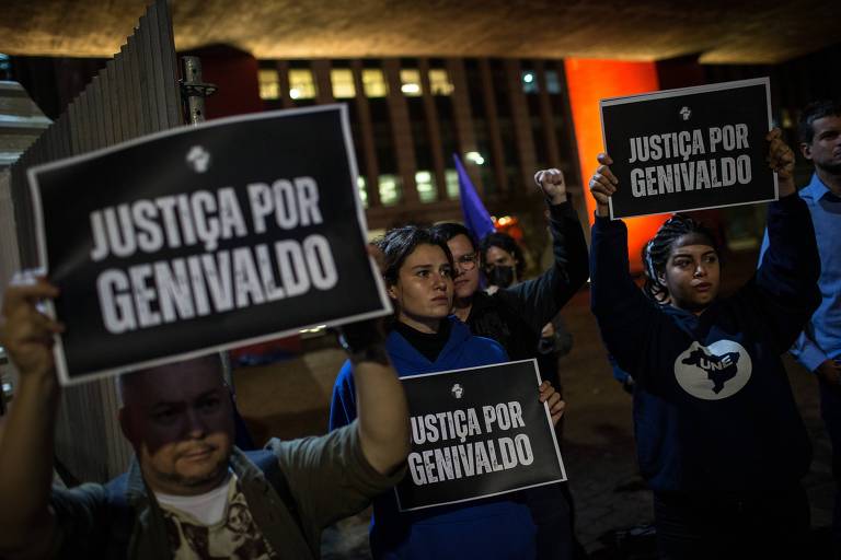 Manifestantes carregam cartazes com a mensagem "Justiça por Genivaldo"