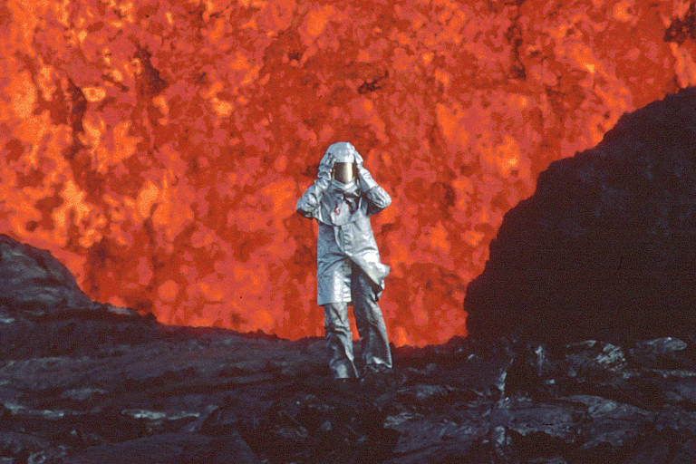 A vulcanóloga Katia Krafft com trajeto protetor de alumínio em frente a uma explosão de lava no vulcão Krafla, na Islândia. A vida dela e seu marido, Maurice Krafft, também vulcanólogo, são retratados no documentário 'Fire of Love', de Sara Dosa
