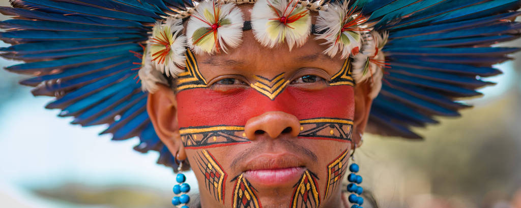 Fotografia colorida do indígena Tukumã Pataxó, em primeiro plano