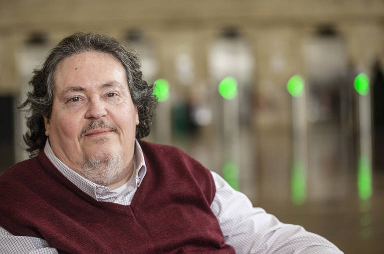 O servidor público Luiz Carlos Lopes, 60, no saguão da Prefeitura de São Paulo; tetraplégico em decorrência da poliomielite, ele afirma trabalhar com um fone de ouvido que lhe permite fazer e atender ligações pelo computador