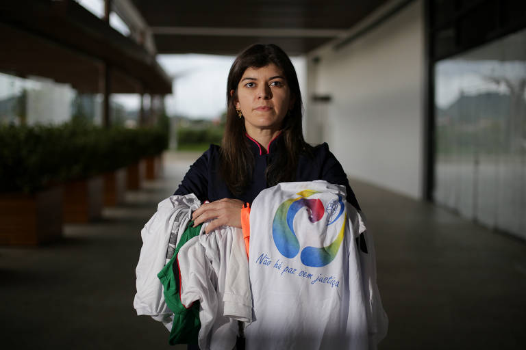 Enfermeira que atuou na boate Kiss, Patrícia Curti Bueno mantém contato com familiares das vítimas; na foto, ela está em um shopping de Santa Maria com o colete usado no dia da tragédia e as camisetas de ações organizadas por familiares de vítimas e sobreviventes