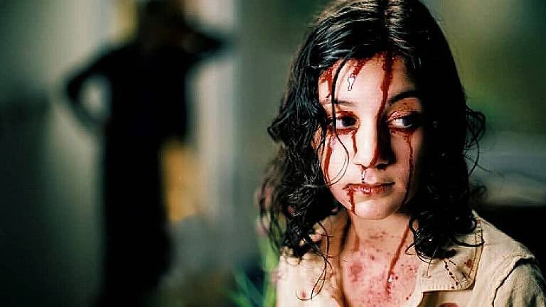 Uma garota está coberta por sangue.