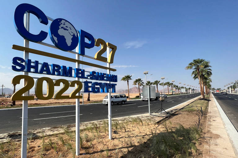 Vista de estrada asfaltada com uma placa o canteiro central chamando para a COP27 em Sharm el-Sheikh, no Egito