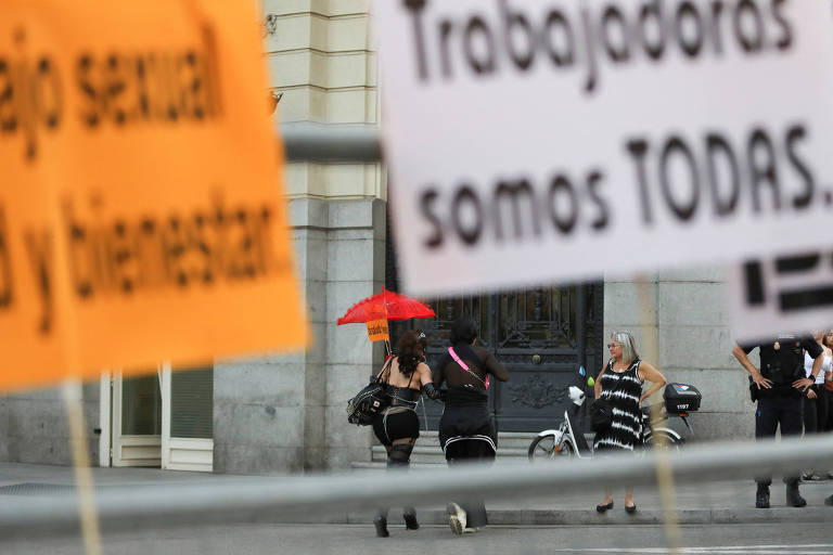 Cartaz onde se lê "trabalhadoras somos todas" preso numa cerca após protesto em Madri contra a lei que visa endurecer penas ligadas à prostituição na Espanha
