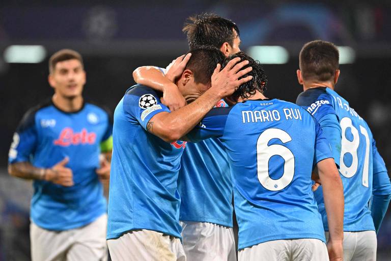 Jogadores do Napoli, com camisas azul-claro e calções brancos, se abraçam para comemorar gol contra o Rangers na Champions League